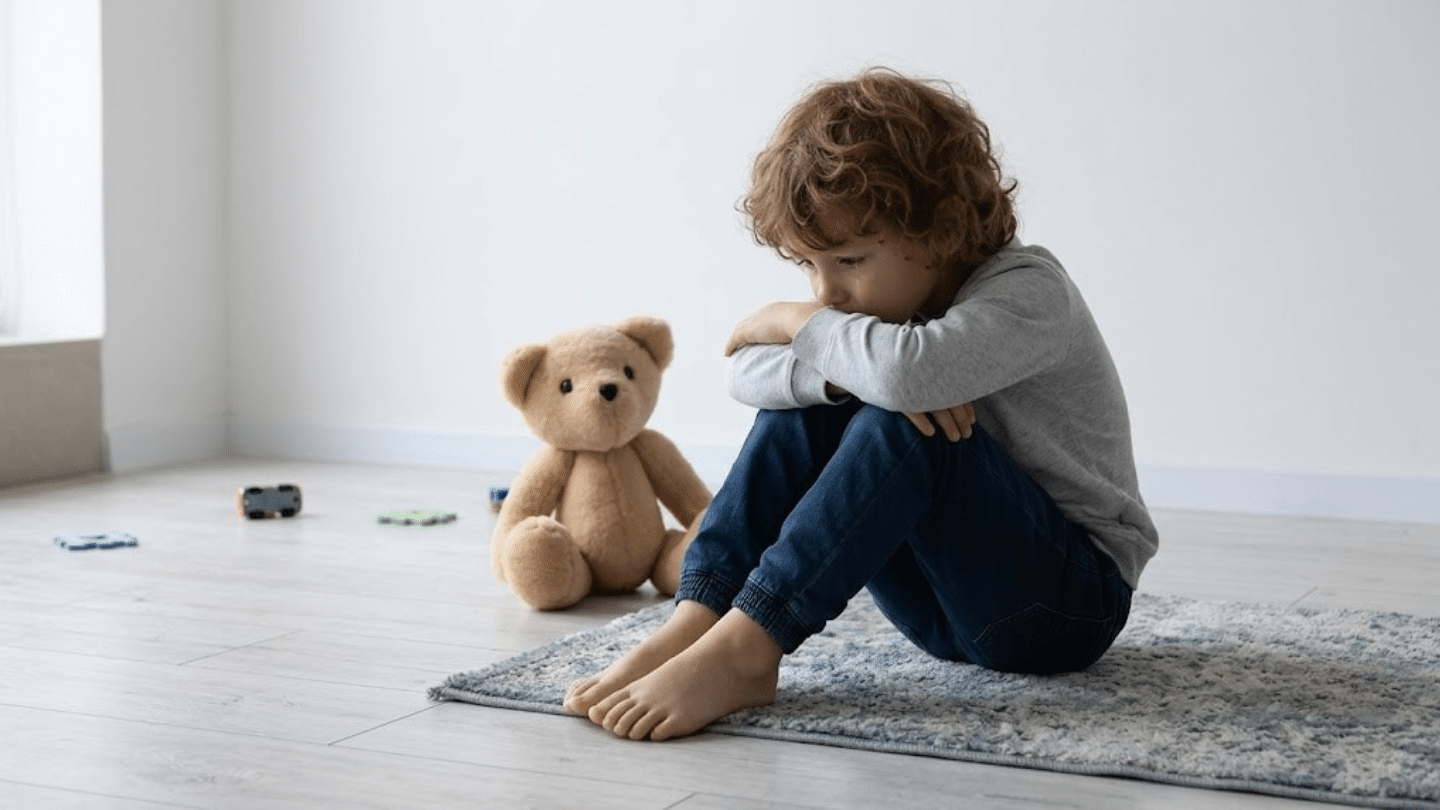 childhood emotional neglect illustrated by a sad child sitting alone on a rug beside a teddy bear in a quiet room