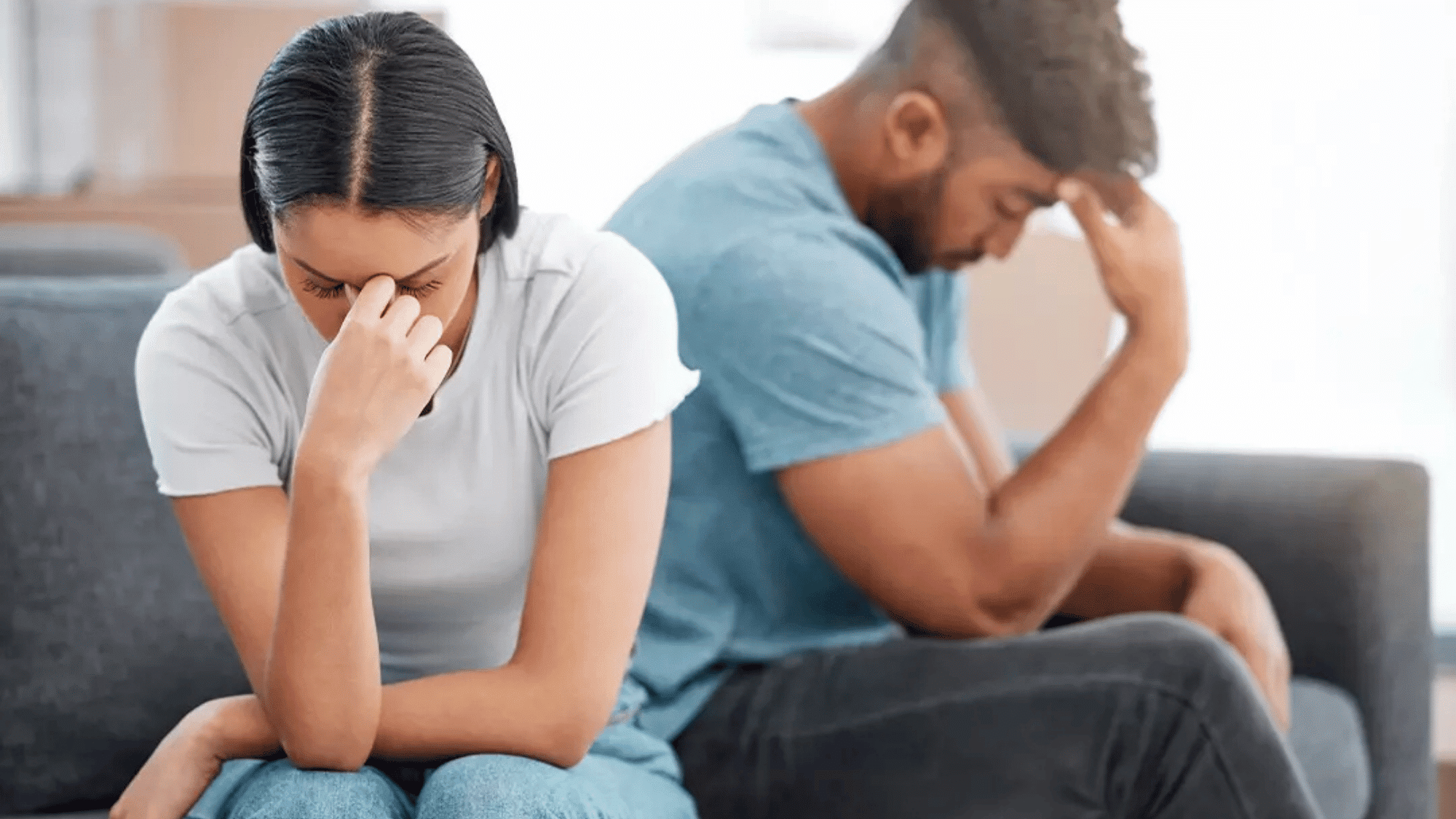 couple sitting apart in emotional distress reflecting relationship conflict trust issues and the impact of betrayal trauma symptoms