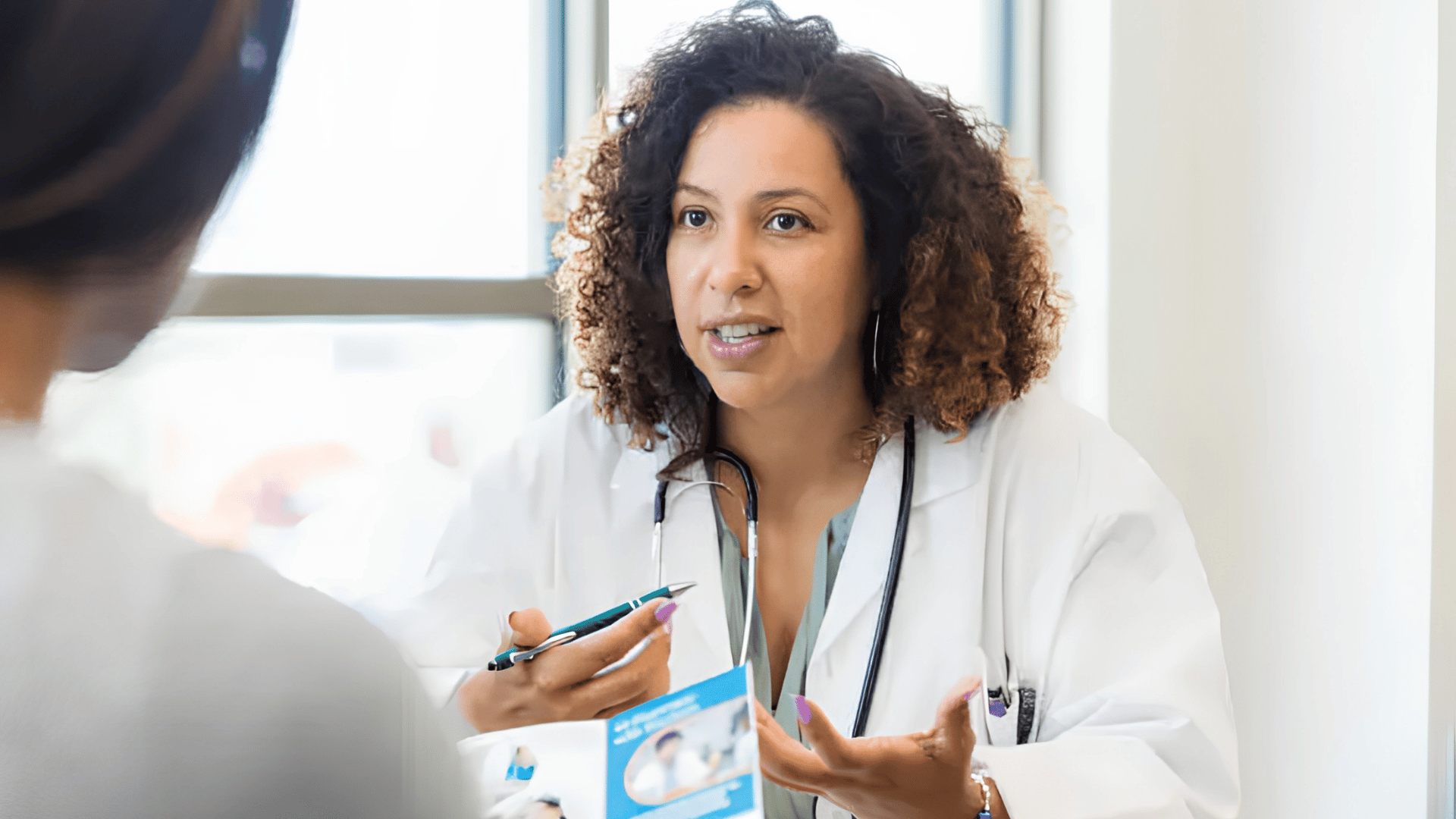 doctor in a white coat explaining information to a patient during a consultation