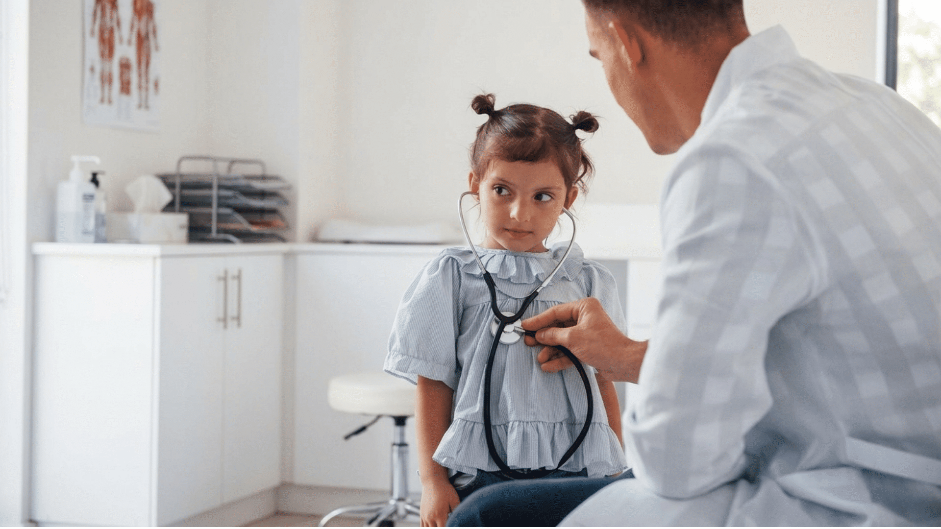 doctor listening to a young girls chest with a stethoscope in a clinic