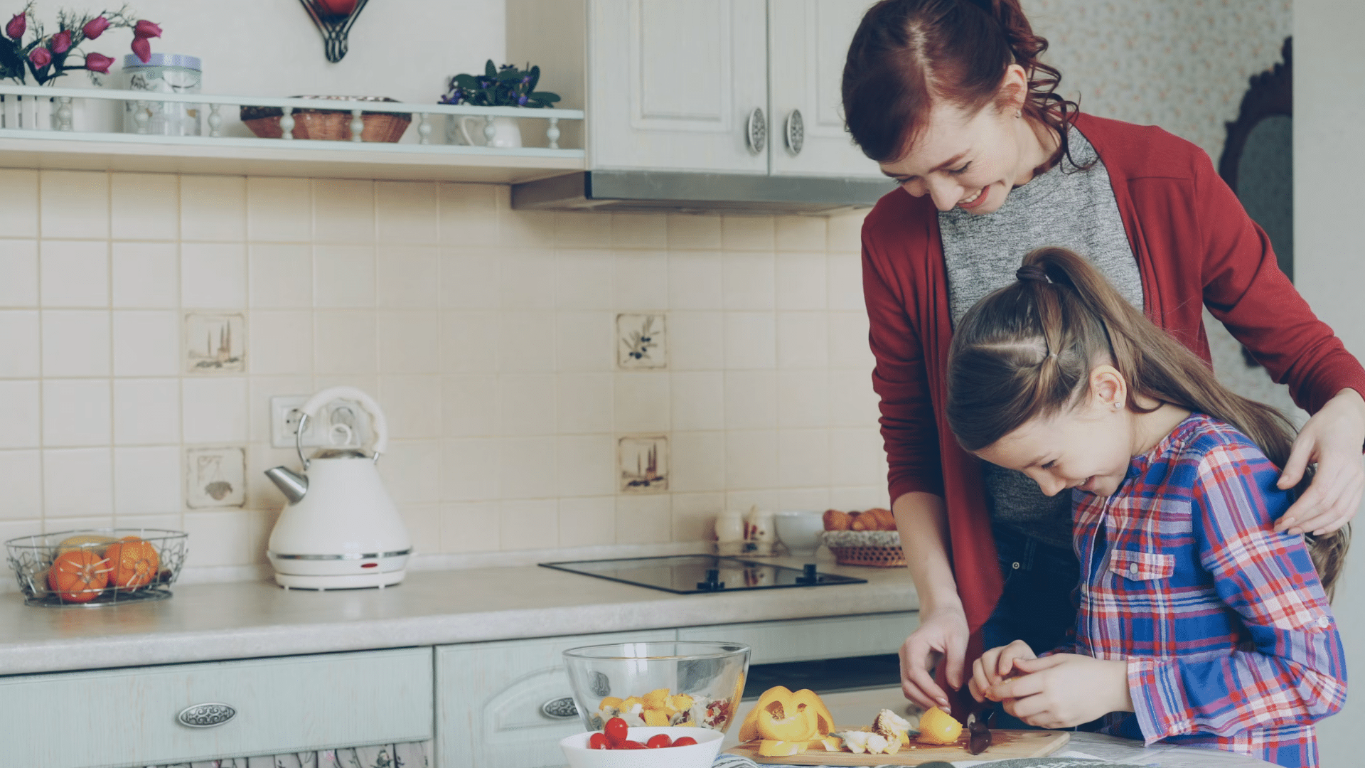 mother and daughter smiling while preparing fresh vegetables together in a bright home kitchen