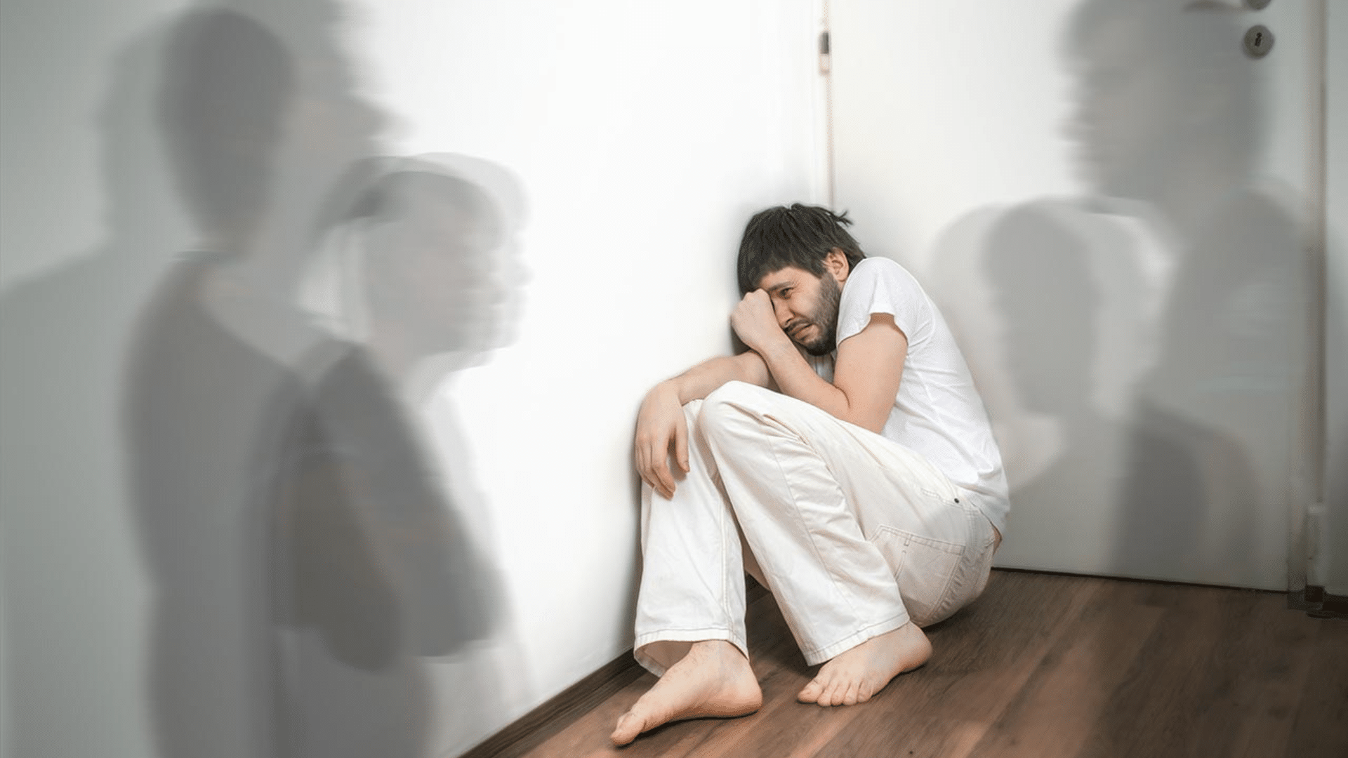 person experiencing distress with blurred figures symbolizing hallucinations psychosis and schizophrenia related symptoms
