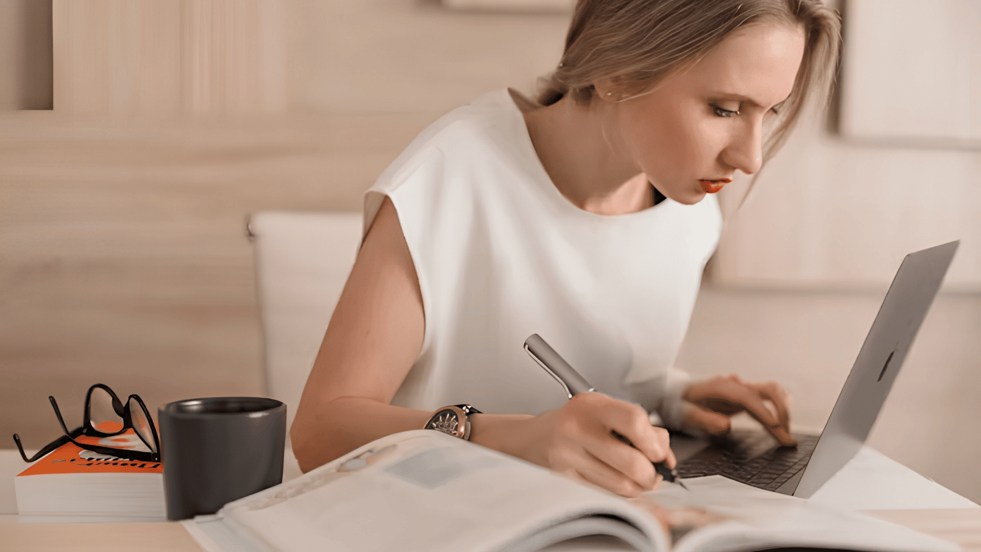 person studying with a laptop and notebook at a cozy home workspace