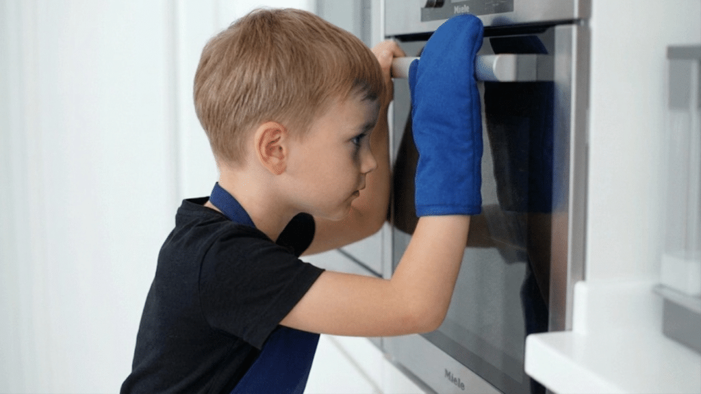 child patiently watching cookies bake in the oven while practicing waiting and self control in the kitchen